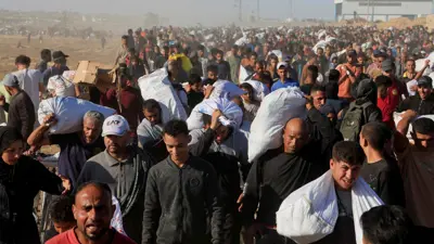 فلسطينيون يحملون إمدادات مساعدات من مؤسسة غزة الإنسانية