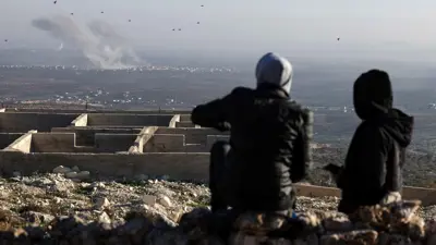 أشخاص يتابعون الاشتباكات عن بعد في حلب