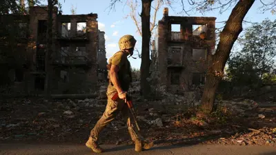 جندي أوكراني قرب مبنى سكني دمرته غارة جوية روسية