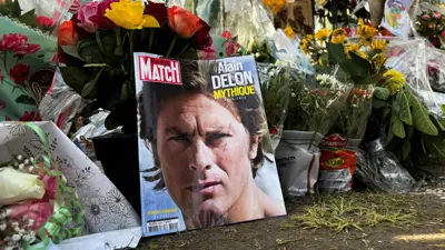 صورة للممثل الفرنسي الراحل آلان ديلون على صحيفة باريس ماتش الفرنسية بين باقات الزهور