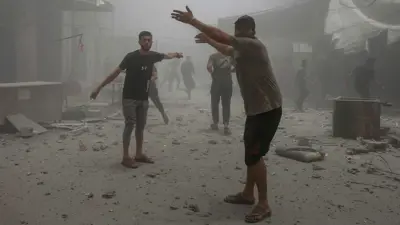 فلسطينيون يتفقدون الدمار في موقع غارة إسرائيلية على منزل بمدينة غزة