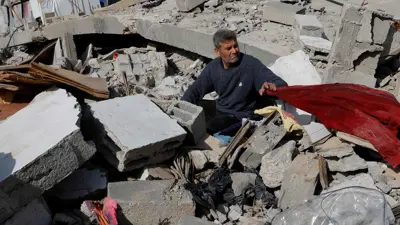 فلسطيني يجلس فوق ركام منزله في قطاع غزة