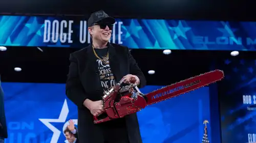 ماسك يحمل منشارا كهربائيا