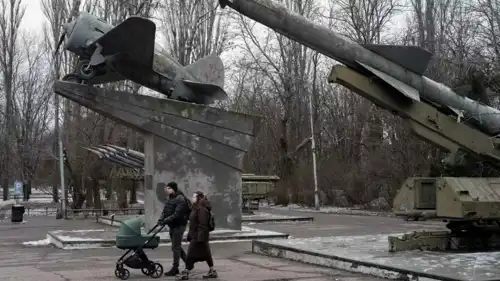 زوجان يسيران قرب أسلحة ومعدات حربية في اوكرانيا