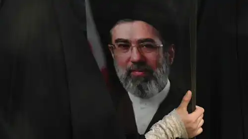 سيدة إيرانية ترفع صورة المرشد الجديد مجتبى خامنئي