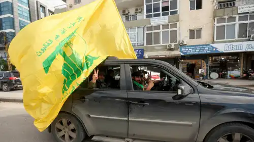 رجل يحمل علم حزب الله، في مدينة صور، جنوب لبنان