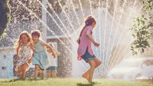أطفال يلعبون بالماء خلال الصيف