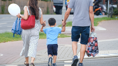 زوج وزوجة يمسكان بيد طفلهما