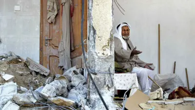فلسطيني يجلس في منزله بعد أن هدمته إسرائيل في وقت سابق 