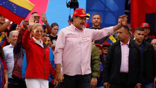 مادورو يلوّح بيده ممسكًا بيد زوجته سيليا فلوريس