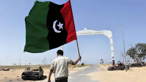 شخص يحمل العلم الليبي