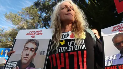 متظاهرة ترفع صور هشام السيد المحتجز في غزة