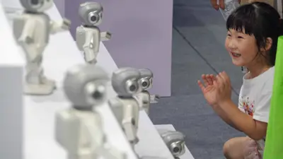 طفل يراقب روبوتًا بشريًا