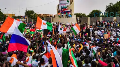 أعلام روسيا والنيجر في وقفة احتجاجية