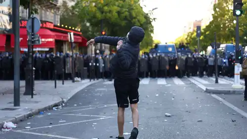 متظاهر يرشق الشرطة في احتجاجات باريس الخميس