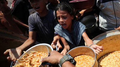 طفلة في غزة تحاول الحصول على الطعام