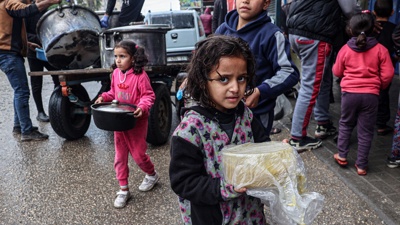طفلة في غزة تحمل بيدها وعاء من الطعام
