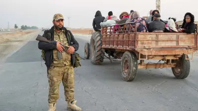 مسلح على طريق حلب الرقة أثناء نزوح أكراد سوريين