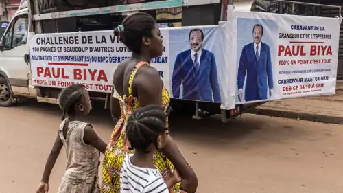 أم تعبر الطريق مع أطفالها أمام شاحنة تحمل ملصقات دعائية لبول بيا