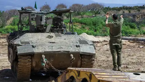 جندي إسرائيلي يوجه ناقلة جند أثناء نقلها قرب حدود لبنان