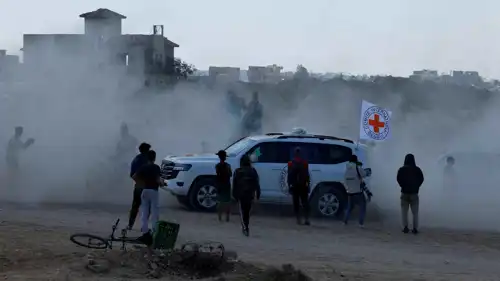 فلسطينيون يتجمعون حول مركبة تابعة للصليب الأحمر تنقل رهائن