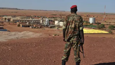 جندي نيجري يسير خارج منجم يورانيوم تابع لشركة فرنسية