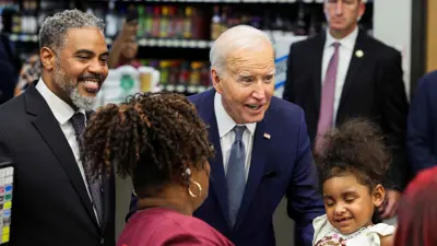 الرئيس الأمريكي جو بايدن يقف مع طفل أثناء توقفه في متجر بقالة في لاس فيغاس