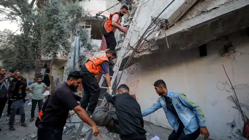 فلسطينيون يتفقدون موقع غارة إسرائيلية في مدينة غزة