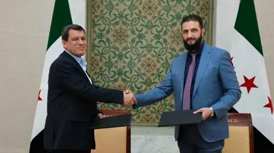 الشرع وعبدي خلال التوقيع على اتفاق الدمج