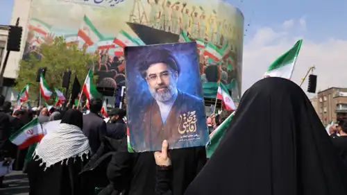 سيدة ترفع صورة لمجتبى خامنئي