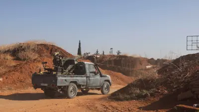 مقاتلون يقودون شاحنة صغيرة محملة بسلاح في بلدة سراقب بمحافظة إدلب شمال غرب سوريا