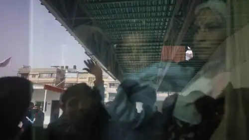 انعكاس زجاج حافلة تهم بمغادرة غزة عبر معبر رفح إثر افتتاحه اليوم