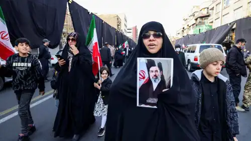 سيدة إيرانية ترفع صورة المرشد الجديد مجتبى خامنئي