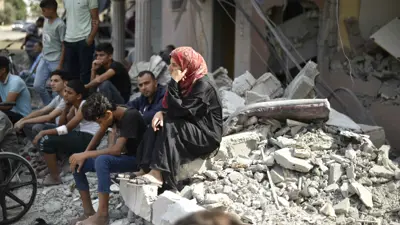 فلسطينيون يجلسون على أنقاض منازلهم في غزة