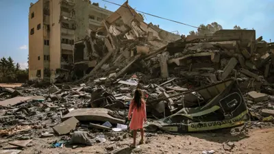 فتاة صغيرة تقف وسط أنقاض مبنى في غزة