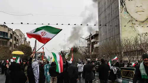 إيرانيون يرفعون علم بلادهم على وقع القصف 