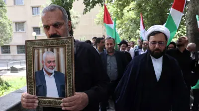 إيرانيون يرفعون صورة هنية في طهران