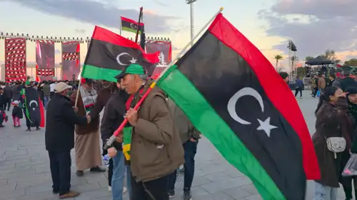 مواطن ليبي يرفع بلاده في إحدى الساحات العامة