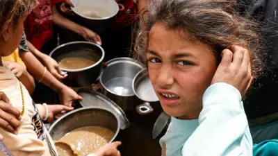 أطفال يحاولون الحصول على الطعام في غزة