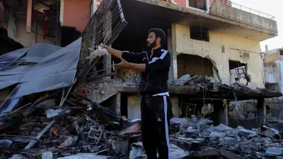 لبناني يقف على أنقاض مبنى دمر بقصف إسرائيلي