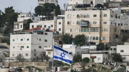 العلم الإسرائيلي في مستوطنة تقع قرب حي فلسطيني في الضفة