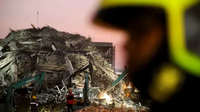 يعمل أفراد الإنقاذ بموقع مبنى انهار في بانكوك