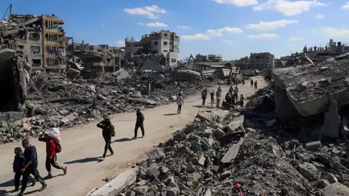 رجال يسيرون بين الأنقاض في مدينة غزة