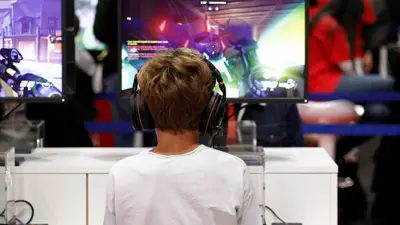 طفل يستعرض لعبة إلكترونية خلال معرض تجاري لألعاب الفيديو في باريس، فرنسا