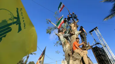 أنصار مليشيا حزب الله يرفعون العلم الإيراني في جنوب لبنان