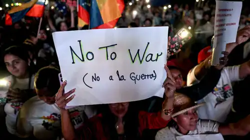 أحد مؤيدي مادورو يحمل لافتة خلال مسيرة تطالب بالسلام 