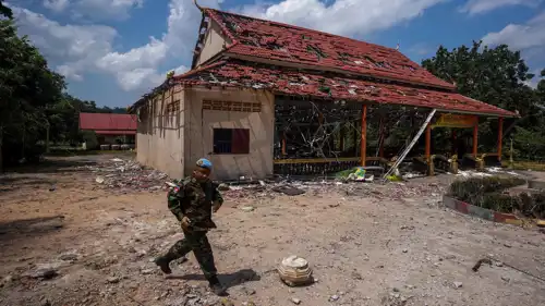 جندي يسير أمام مبنى تضرر من جراء المدفعية بين تايلاند وكمبوديا 