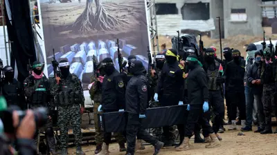 عناصر من حركة حماس خلال تسليم جثث رهائن في غزة