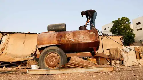  فلسطيني يملأ خزان مياه في بردلة بالضفة الغربية