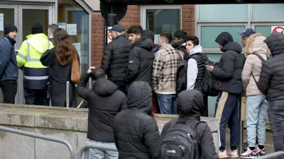 مهاجرون يصطفون للحصول على طلبات لجوء